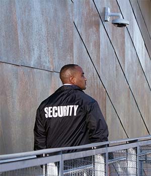 Security guard walking upstairs with a security camera above him