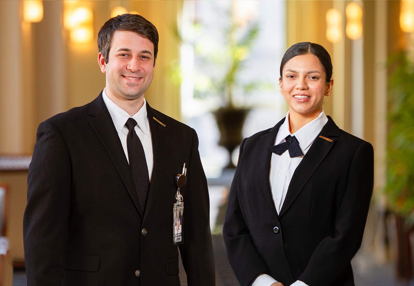 Two concierge security guards posing for a picture in the lobby of the client site they are guarding