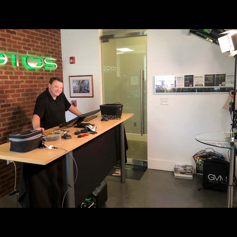 man smiling behind desk at protos security office