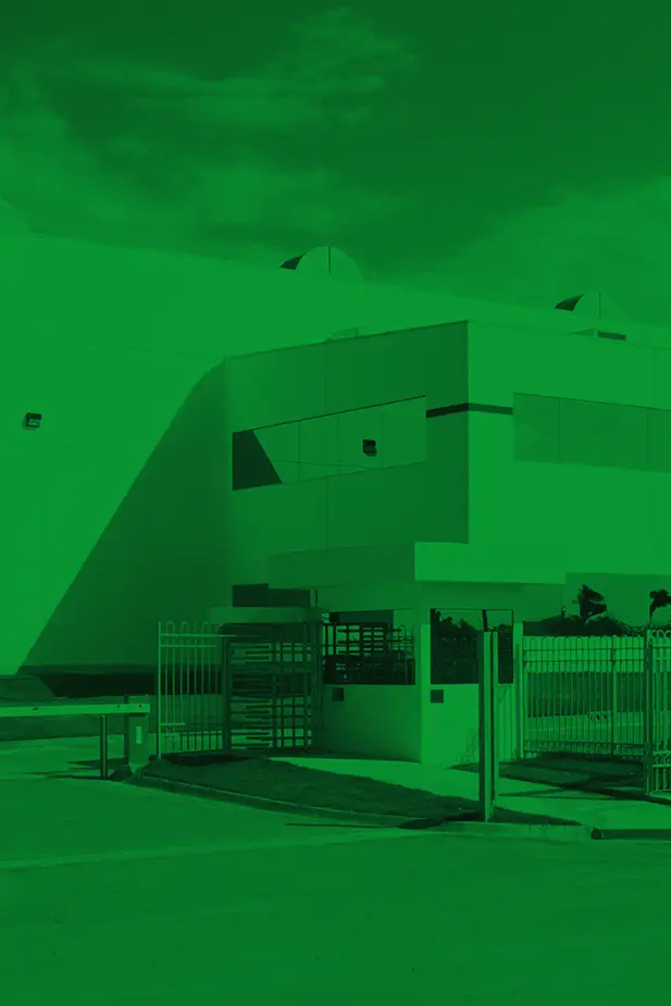 manufacturing facility with a guard station in front. with a green overaly