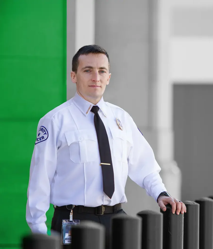 security officer confidently standing with his hands resting on security bollards
