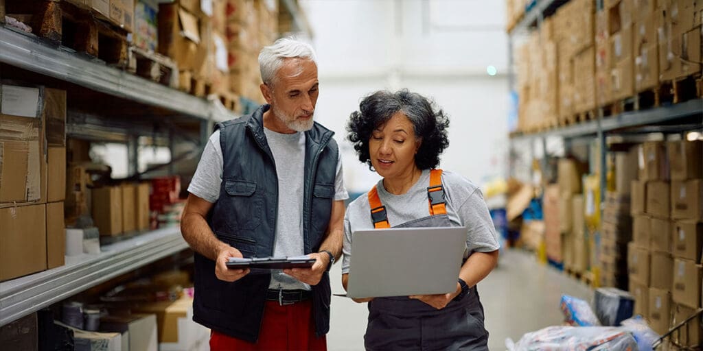 Two warehouse employees review inventory data together