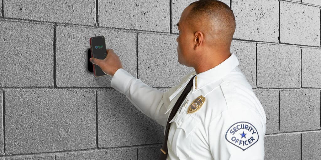 A uniformed security officer in a white shirt scans a checkpoint
